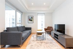 a living room with a couch and a tv at The Hunt Cherrywood in Loughlinstown