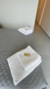 a bed with a white blanket and a towel on it at Alma de mar in Mar del Plata