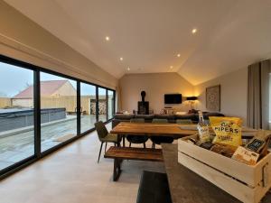 un salon avec une table et un canapé dans l'établissement Rowan House, Ashlin Farm Barns, à Lincoln