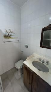 a white bathroom with a sink and a toilet at Pousada Buganvilia in Bombinhas +19 photos