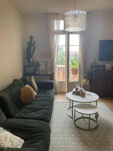 ein Wohnzimmer mit einem grünen Sofa und einem Tisch in der Unterkunft Cosy flat next Casino in Monaco in Beausoleil