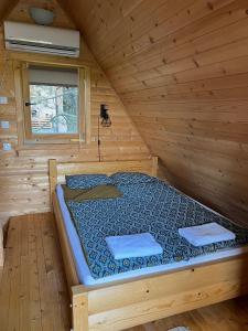 Bett in einem Holzzimmer in einer Hütte in der Unterkunft Brvnare Spasić in Vinci