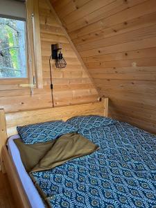 ein Schlafzimmer mit einem Bett in einer Holzhütte in der Unterkunft Brvnare Spasić in Vinci
