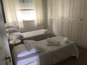 2 camas individuales en una habitación con ventana en Luxo Frente Mar Copacabana, en Río de Janeiro