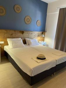 Gennadi Beach Apartments في غينادي: غرفة نوم بسرير كبير وعليه قبعة