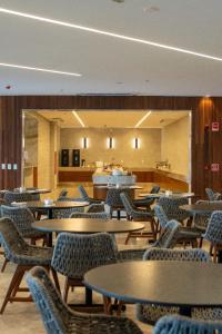 uma sala com mesas e cadeiras e uma cafetaria em Salinas Premium Resort em Salinópolis