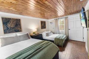 1 dormitorio con 2 camas y techo de madera en Tropical Oasis Located Near Lake With Pool and Hot Tub en West Palm Beach