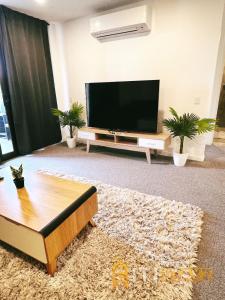 a living room with a flat screen tv and a couch at Contemporary in Kingston-2bd Apt in Kingston 