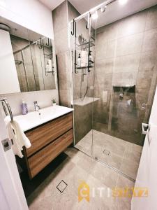 a bathroom with a shower and a sink and a glass shower door at Contemporary in Kingston-2bd Apt in Kingston 