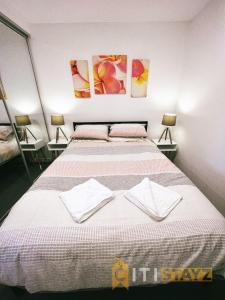 a bedroom with two beds and two paintings on the wall at Contemporary in Kingston-2bd Apt in Kingston 