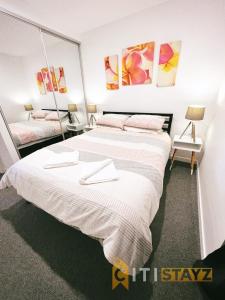 una camera con due letti con lenzuola bianche di Contemporary in Kingston-2bd Apt a Kingston 