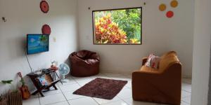 sala de estar con sofá y ventana en Casa Sossego da Mata, en Itacaré