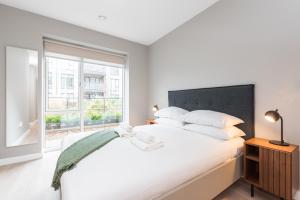 a bedroom with a large white bed and a window at Woodward Square in Dublin