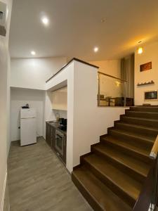 a staircase leading to a kitchen with a refrigerator at Silver Mountain Apartment in Poiana Brasov