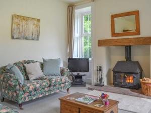 a living room with a couch and a fireplace at Monkwood Cottage in Hale