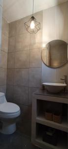 a bathroom with a toilet and a sink and a mirror at Casa Puclaro, terraza panorámica Valle del Elqui in Vicuña +31 photos