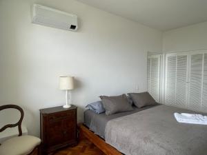 1 dormitorio con cama, lámpara y silla en Santa Teresa Luxury Flat. Sugar-Loaf Amazing View, en Río de Janeiro