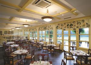a dining room with tables and chairs and windows at Dar es Salaam Serena Hotel in Dar es Salaam