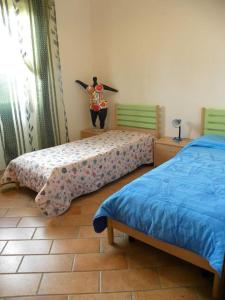 a room with two beds and a person holding a surfboard at Su Suergiu in San Giovanni Suèrgiu