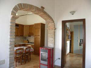 un arco in una cucina con tavolo e sala da pranzo di Su Suergiu a San Giovanni Suèrgiu