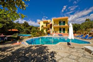 a villa with a swimming pool in front of a house at Zako Apartments in Limenaria
