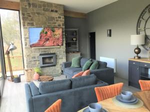 a living room with two couches and a stone fireplace at Yorkshire Dales Lodge 10 Ensuite in Richmond