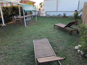 a couple of chairs and a table in a yard at Villetta a schiera nei pressi del mare in Livorno