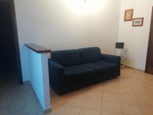 a blue couch in a room with a table at Villetta a schiera nei pressi del mare in Livorno