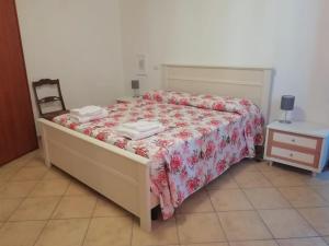 a bedroom with a bed and a chair and a table at Villetta a schiera nei pressi del mare in Livorno