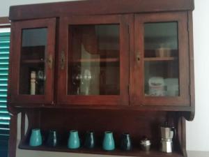 a wooden cabinet with a bunch of vases sitting on a shelf at Villetta a schiera nei pressi del mare in Livorno