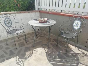 two chairs and a table on a patio at Villetta a schiera nei pressi del mare in Livorno