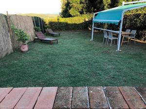 a backyard with a table and chairs and a blue canopy at Villetta a schiera nei pressi del mare in Livorno