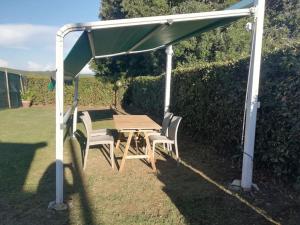 a picnic table and chairs under a canopy at Villetta a schiera nei pressi del mare in Livorno