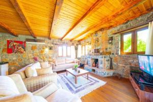 a large living room with a stone wall at Kaya Koy Deluxe Villas Fethiye in Fethiye