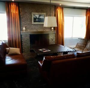 uma sala de estar com um sofá e uma lareira em La Americana, casa entre sierras em Luján