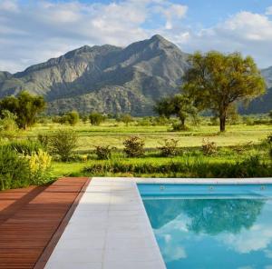 uma piscina com montanhas ao fundo em La Americana, casa entre sierras em Luján