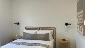 a bedroom with a bed with white sheets and pillows at 4BR Waterfront - Skippers Quarterdeck in Lakes Entrance