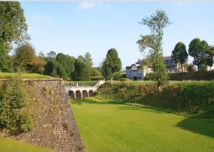 a bridge over a lush green field with a bridge at Studio confort #2, proche Gare et commodités in Maubeuge
