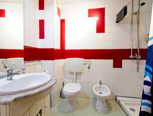 a bathroom with a white sink and a toilet at Ribeira Smart Suite in Porto