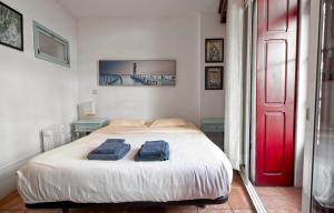 a bedroom with a bed with two blue towels on it at Ribeira Smart Suite in Porto
