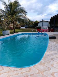 a large blue swimming pool with a swing at Pousada Village Maçarico in Salinópolis