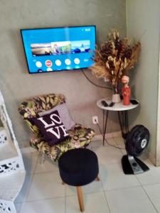 sala de estar con silla y TV de pantalla plana en Loft Búzios, en Búzios