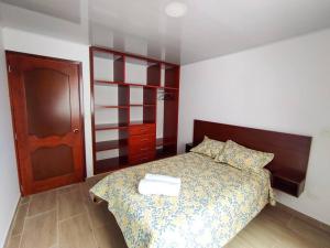 1 dormitorio con 1 cama y puerta de madera en Apartamento en el Centro de Paipa, en Paipa