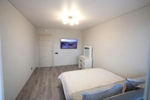 um quarto com uma cama e uma televisão na parede em Maya's Apartment em Vilnius
