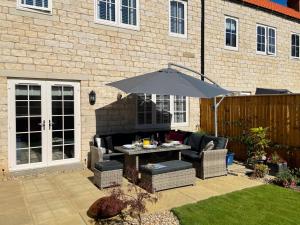 a patio with a table and an umbrella at The Gables in Helmsley