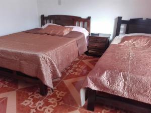 a bedroom with two beds and a dresser at Posada Turística Estancia Real in Sutamarchán