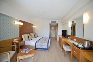 シダにあるTrendy Side Beach Hotelのベッドとリビングルームが備わるホテルルームです。