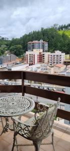 - Balcón con vistas, mesa y silla en AP 52 Centro com varanda, en Serra Negra