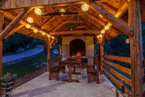 a wooden pavilion with a table and a fireplace at Father's Land in Rakovica