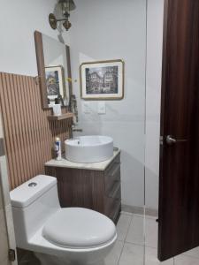 y baño con aseo blanco y lavamanos. en Un confortable hogar en el corazón de la CDMX., en Ciudad de México